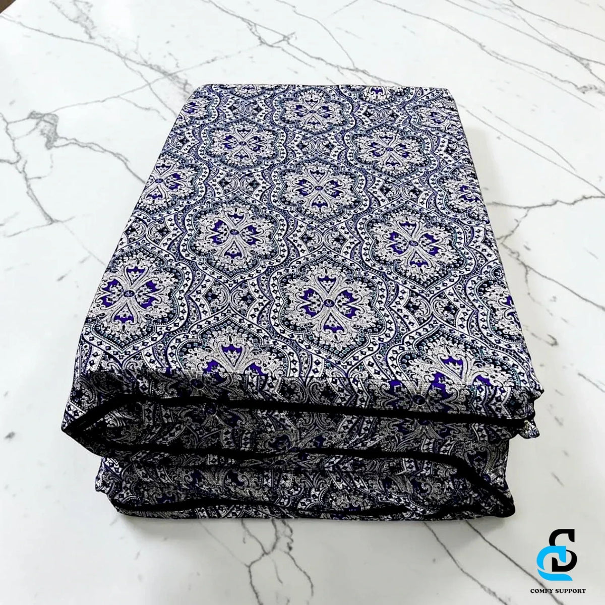 Comfy Support folding mattress cover featuring a blue and white intricate damask pattern on a marble surface
