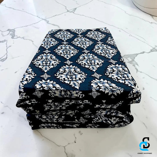 Comfy Support folding mattress cover in a navy blue and white damask print, neatly folded on a marble surface.