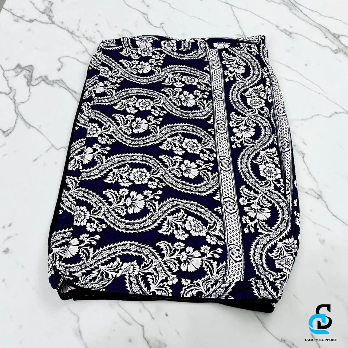 Comfy Support folding mattress cover in a navy blue and white floral paisley print on a white marble surface